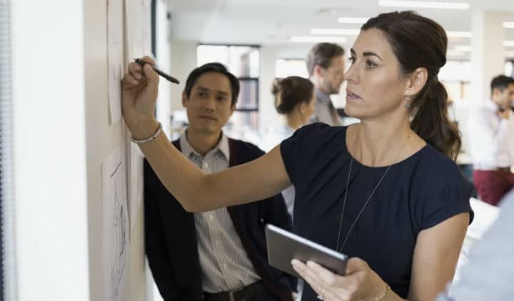 Businesswoman writing at wall 720 x 422