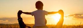 father carrying son shoulders field sunset hero mobile 750x259