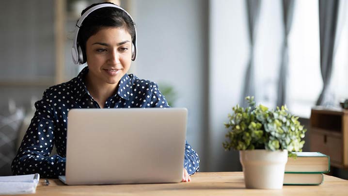 Young Woman Using Headphones Working Remote718x404